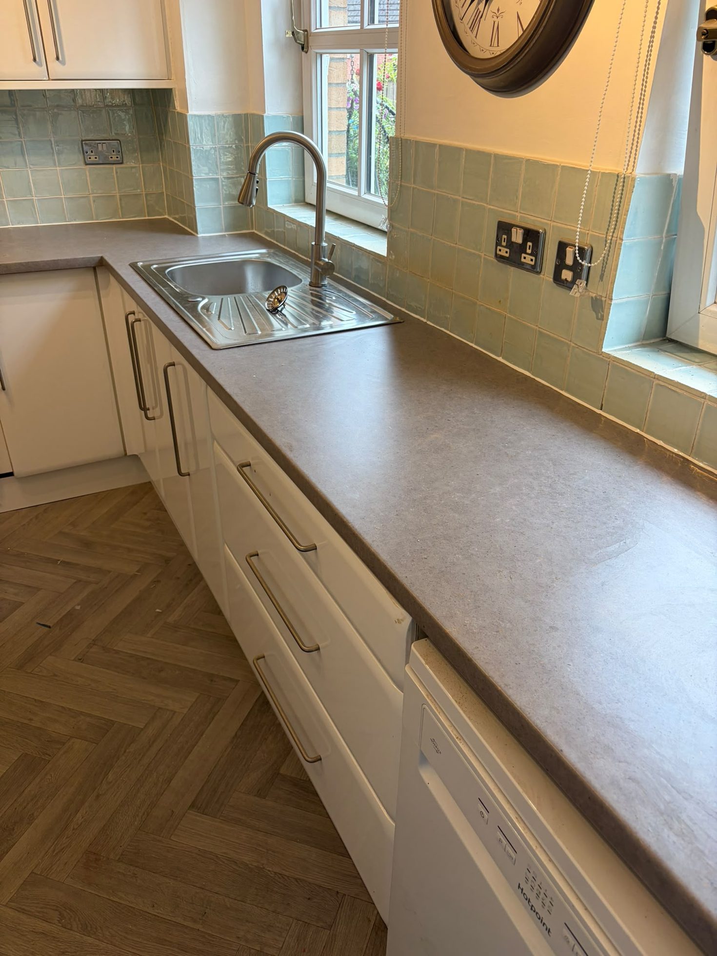 Kitchen run with fitted worktop, inset sink, drawer units and herringbone flooring