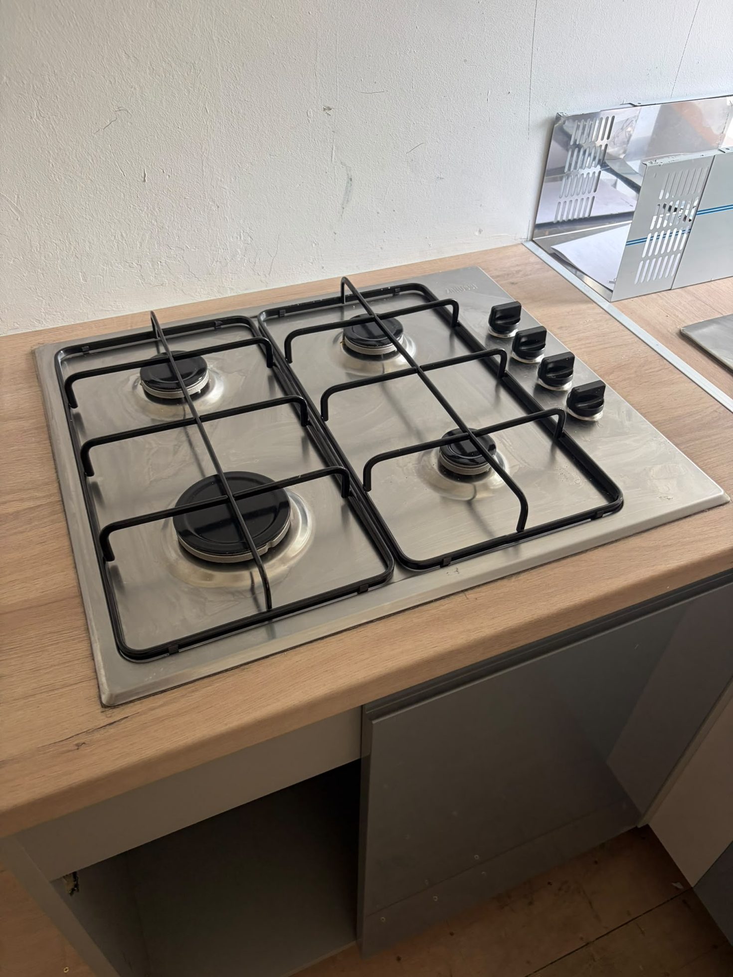 Gas hob cut in and installed into a timber-effect kitchen worktop