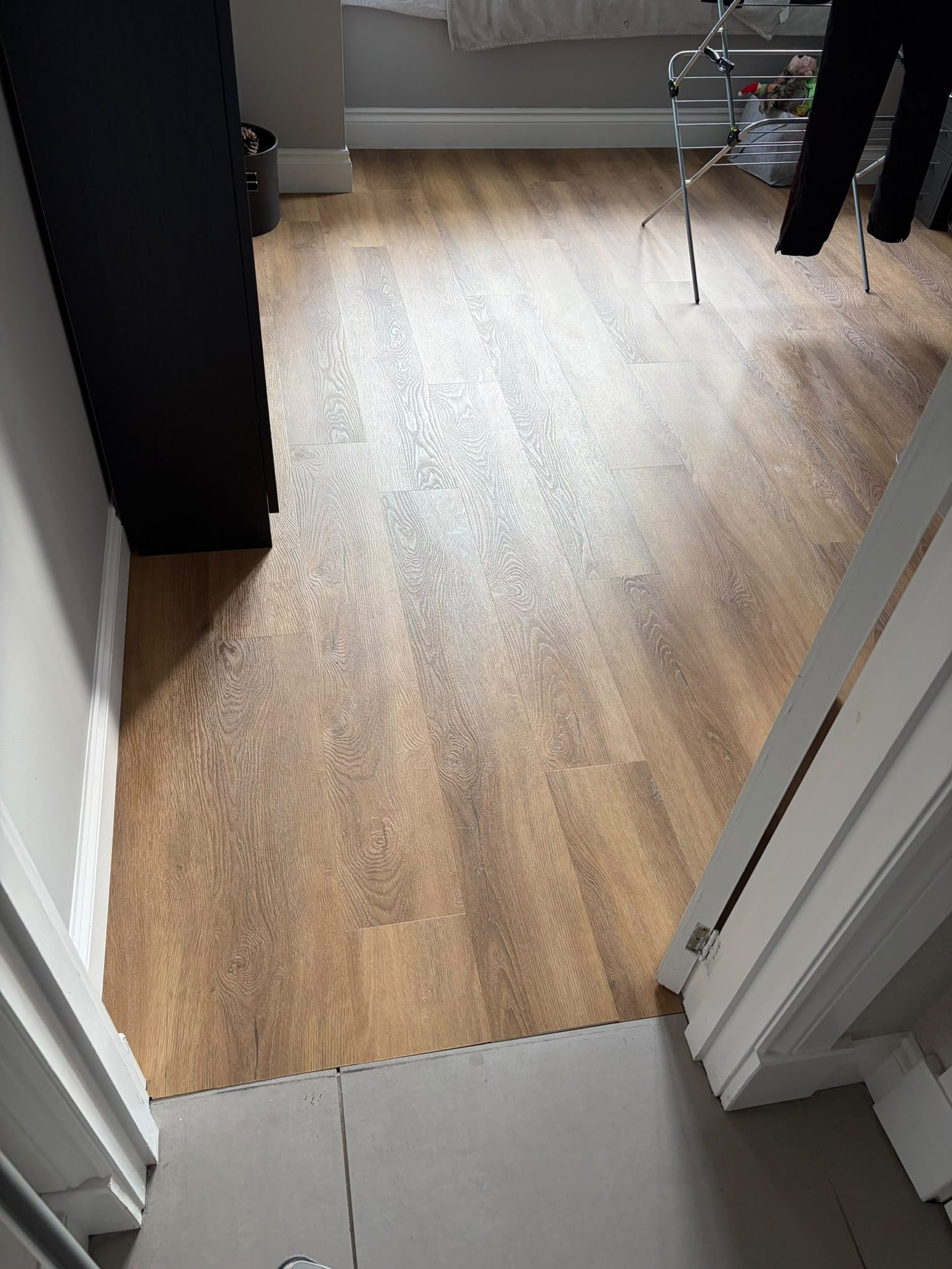 Completed oak-effect floor laid through a doorway with trims neatly finished