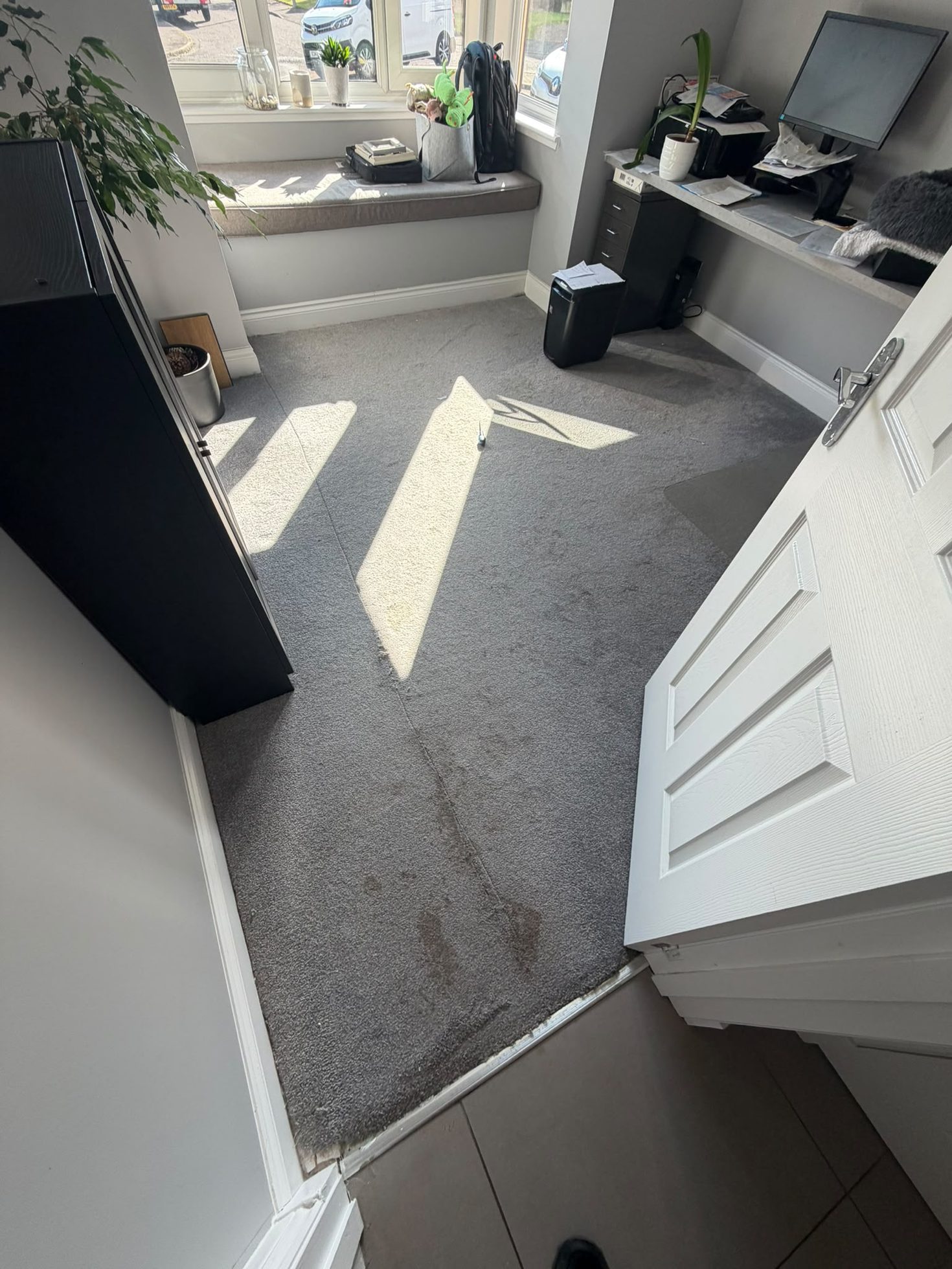 Worn grey carpet lifted before new flooring is installed