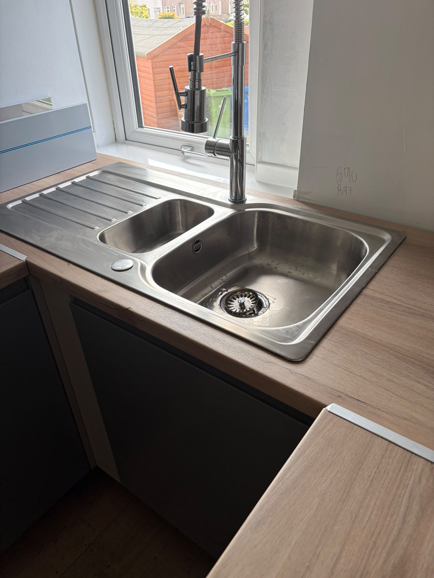 Double stainless sink and chrome pull-out tap installed in a new kitchen worktop