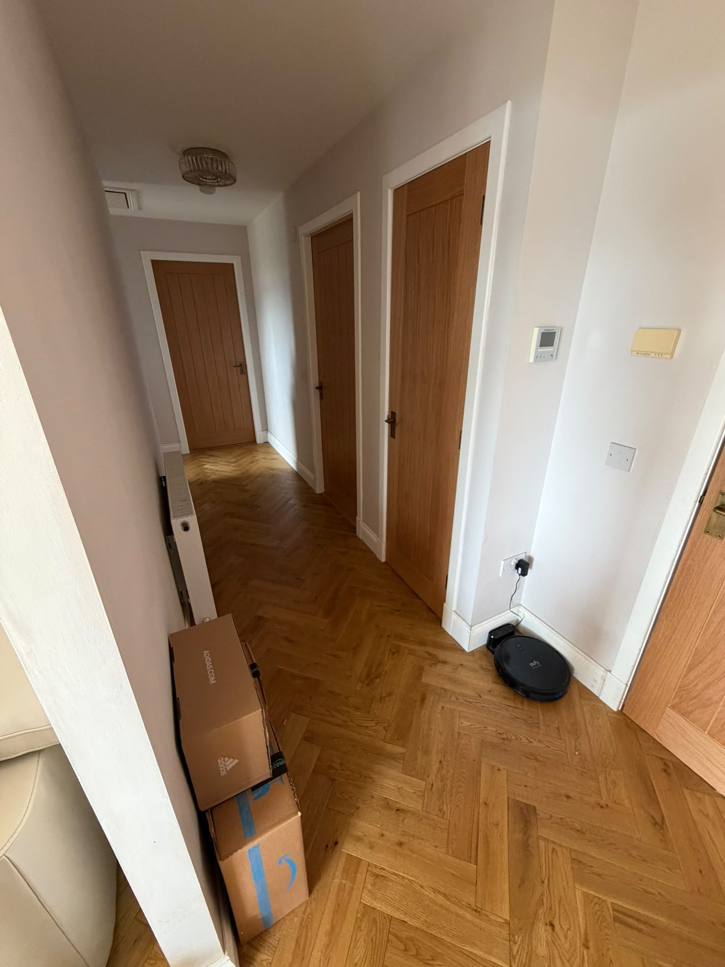 Second-fix carpentry with multiple hung timber doors and herringbone flooring in a Central Belt home