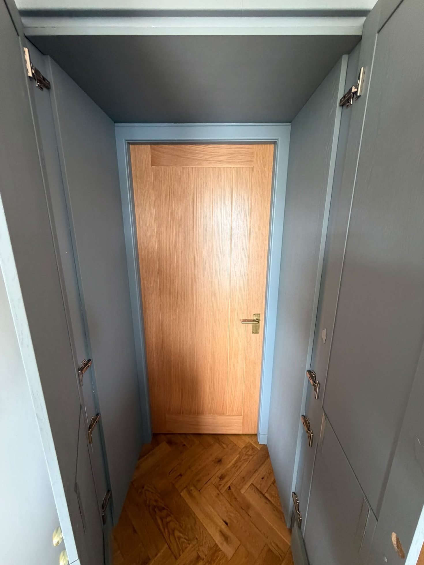 Fitted bespoke joinery and wardrobe units built around an oak internal door by Impact Joinery