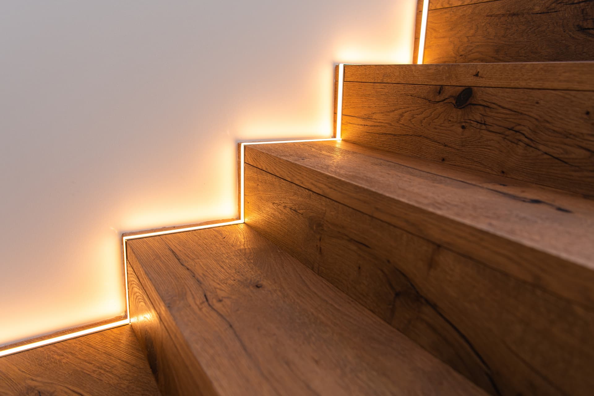Solid oak staircase treads with warm recessed LED lighting along each step, joinery by Impact Joinery, Cumbernauld and Glasgow